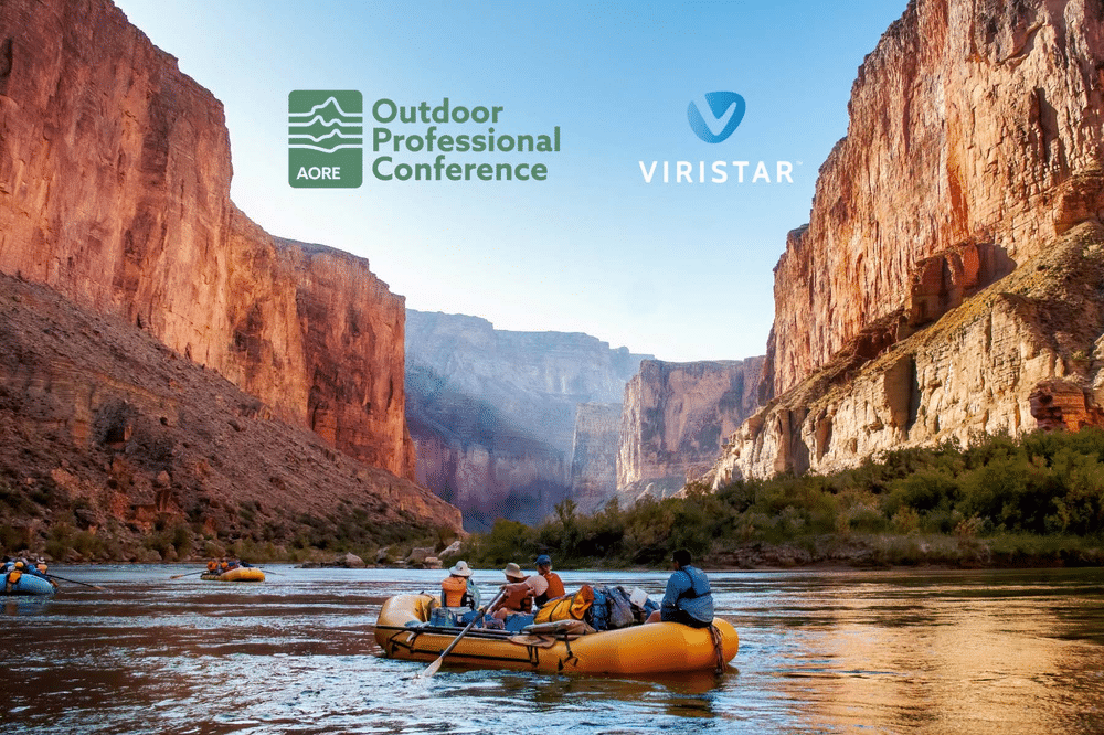 Photo of rafters on a yellow raft navigating through a canyon, with the Outdoor Professional Conference logo and Viristar logo displayed prominently on the image. The raft is surrounded by towering canyon walls.