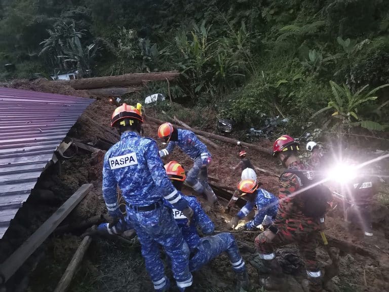 In this photo provided by Civil Defense Department, Civil Defense personnel search for survivors buried after a landslide hit a campsite in Batang Kali, Malaysia, Friday, Dec. 16, 2022. A landslide hit the campsite outside Kuala Lumpur early Friday, Malaysia's fire department said. (Malaysia Civil Defence via AP )