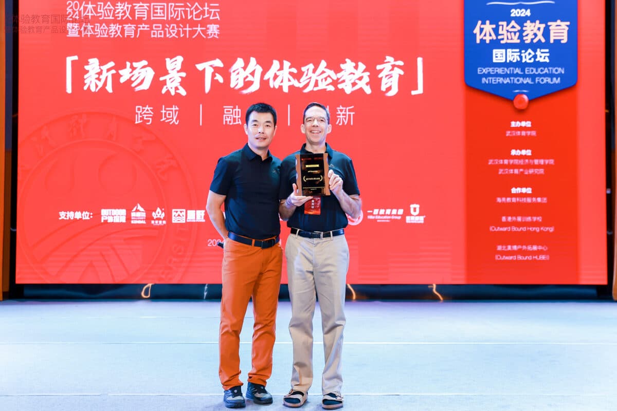 Dr. Xu presents a Keynote Speaker appreciation plaque to Jeff Baierlein, both smiling as they acknowledge the recognition.