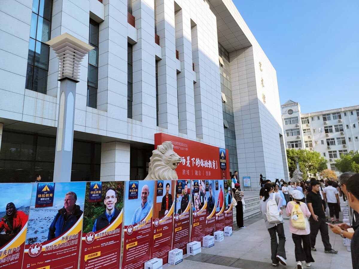 Exterior view of Wuhan Sports University adorned with banners displaying the keynote speakers of the Experiential Education Forum.